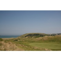 The par-3 17th hole on The Church Course at St. Enodoc Golf Club plays next to a large dune.