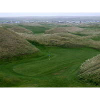 The fifth green on the Old Course at Lahinch Golf Club is shielded by dunes.